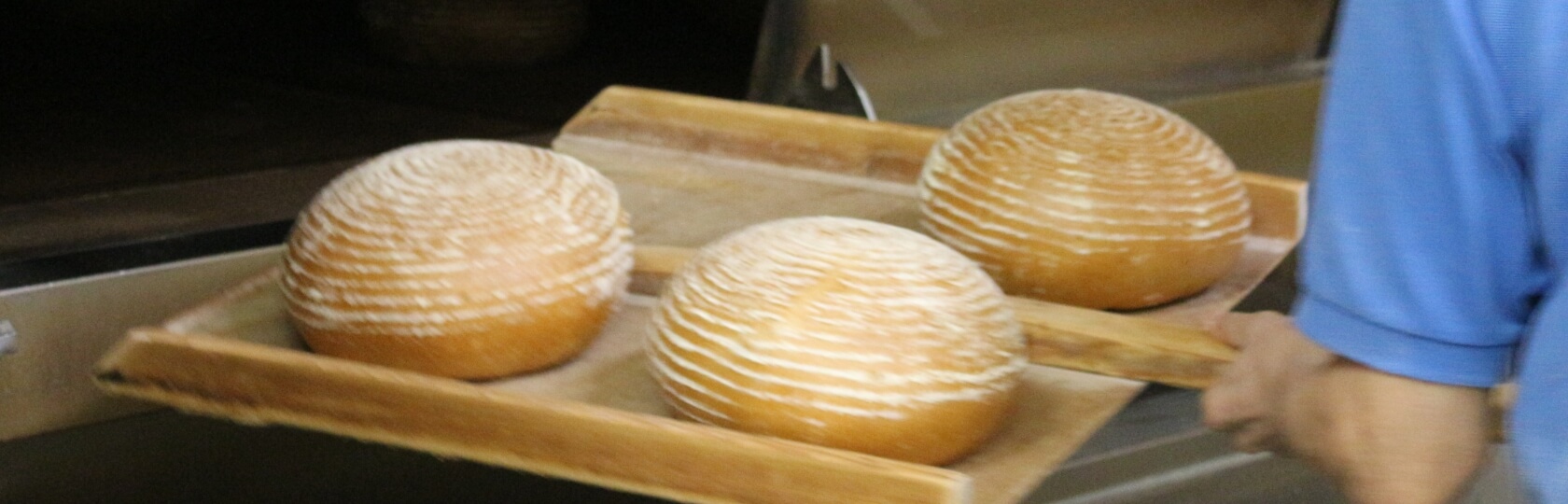 オーブンから出来立てのライ麦パンを取り出す