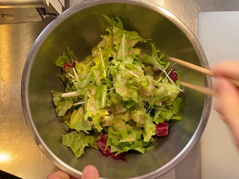 ボウルに入れたサラダを和えている